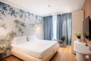 Camera d'albergo moderna con letto matrimoniale e decorazioni.