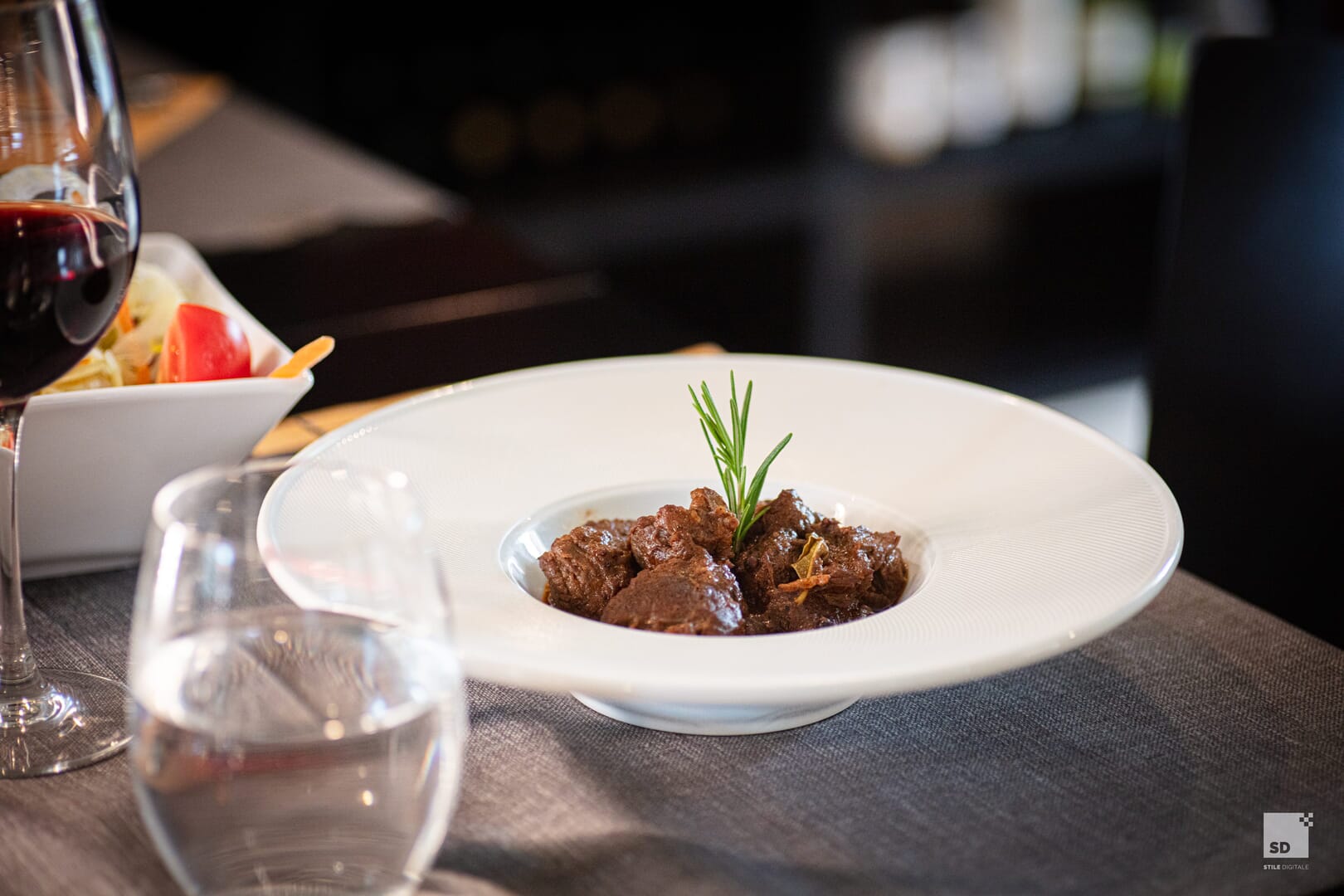 Piatto di carne con rosmarino al ristorante elegante.