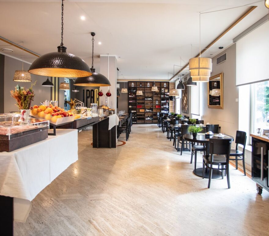 Sala colazione elegante con tavoli e buffet.